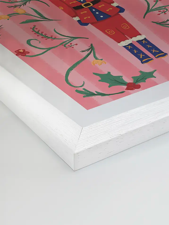 Affiche artistique Casse-Noisette, illustrée par Blanca Flor, présentant un soldat de Noël entouré de houx, de fleurs et d’un grand nœud rouge, parfaite pour apporter une touche festive et élégante sur un fond rose pastel.