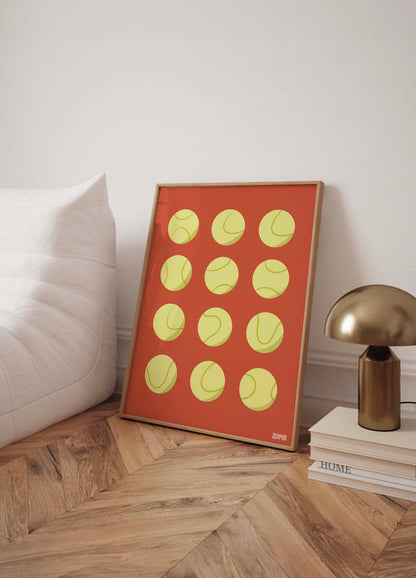 Affiche avec motif de balles de tennis présentée sur un bureau moderne à domicile, apportant une touche de design graphique minimaliste et de sportivité à l'espace de travail.
