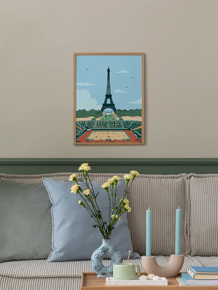 Poster de beach volley avec la Tour Eiffel en arrière-plan, encadré et accroché au mur dans un salon moderne. Idéal pour ajouter une touche de décoration sportive et parisienne à votre intérieur, parfait pour les amateurs de volleyball et de design mural.